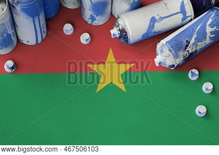 Burkina Faso Flag And Few Used Aerosol Spray Cans For Graffiti Painting. Street Art Culture Concept,