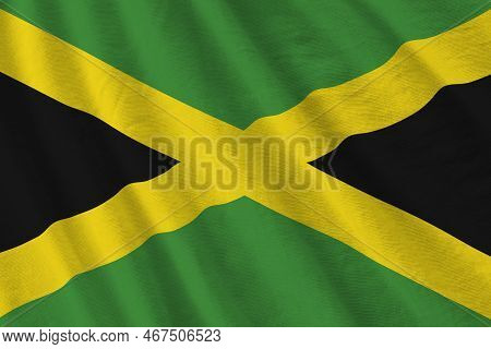 Jamaica Flag With Big Folds Waving Close Up Under The Studio Light Indoors. The Official Symbols And