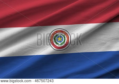 Paraguay Flag With Big Folds Waving Close Up Under The Studio Light Indoors. The Official Symbols An