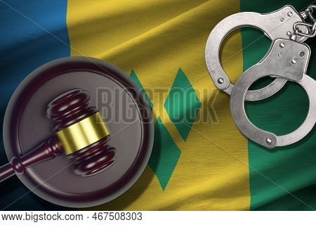 Saint Vincent And The Grenadines Flag With Judge Mallet And Handcuffs In Dark Room. Concept Of Crimi