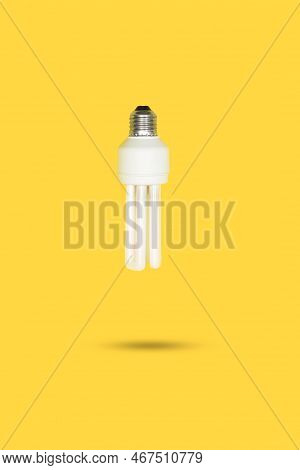 White Lightbulb Floating On A Yellow Background With Copy Space
