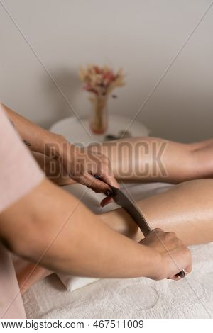 Close-up Of A Female Masseur's Hands Doing Foot Massage With A Metal Medical Massager In The Office.