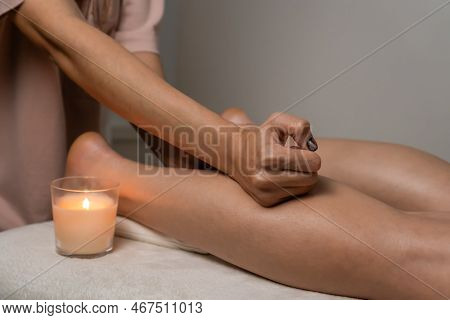 Close-up Of A Female Masseuse Doing A Relaxing Foot Massage To A Client In A Massage Room With A Lit