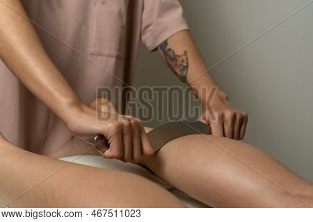 Close-up Of A Female Masseur's Hands Doing Foot Massage With A Metal Medical Massager In The Office.