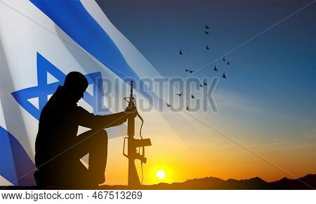 Silhouette Of Soldier Kneeling Down On A Background Of Sunset And Israel Flag. Greetning Card For Na