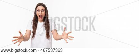 Watch Out. Alarmed And Shocked, Scared Pretty Girl Raising Hands To Catch Something That Person Thro