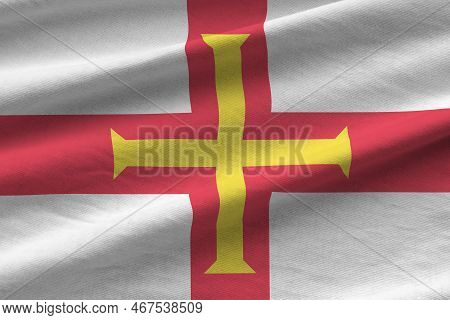Guernsey Flag With Big Folds Waving Close Up Under The Studio Light Indoors. The Official Symbols An