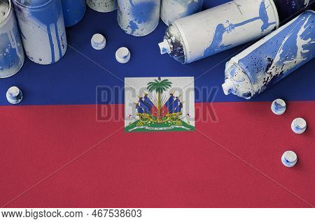Haiti Flag And Few Used Aerosol Spray Cans For Graffiti Painting. Street Art Culture Concept, Vandal