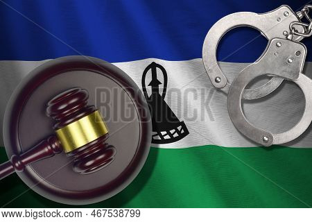 Lesotho Flag With Judge Mallet And Handcuffs In Dark Room. Concept Of Criminal And Punishment, Backg