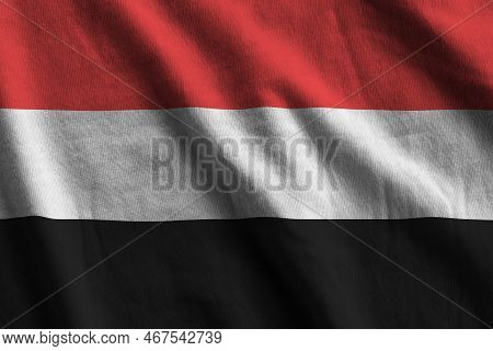 Yemen Flag With Big Folds Waving Close Up Under The Studio Light Indoors. The Official Symbols And C
