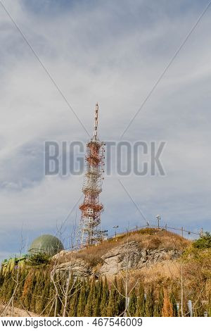 Communications Tower Under Cloudy Sky.