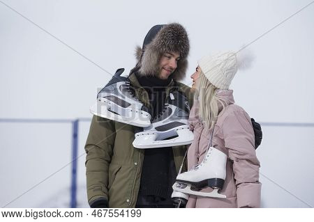 Loving Caucasian Couple On Skatingrink With Ice Skates Posing Together Over A Snowy Winter Landscape