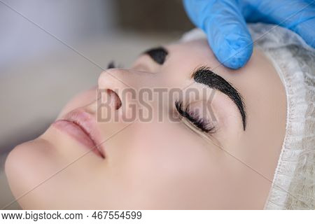 Beauty And Healthy Lifestyle Ideas. Young Beautiful Woman Having Permanent Make-up Tattoo On Eyebrow
