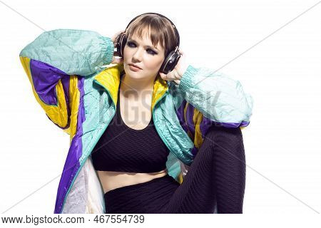 Portrait Of Young Caucasian Female  Sportwoman In Fitness Outfit Wearing Wireless Phones While Liste