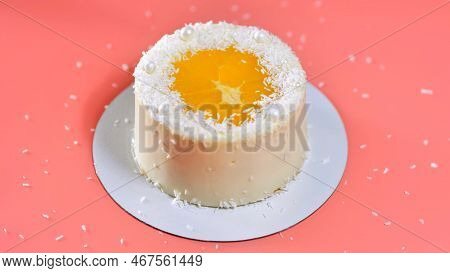 Cake With Orange And Coconut Shavings Spun On A Pink Background.
