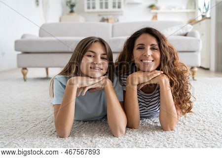Charismatic Cheerful Woman And Teen Girl Lying On Floor With Carpet Posing For Family Photo. Positiv