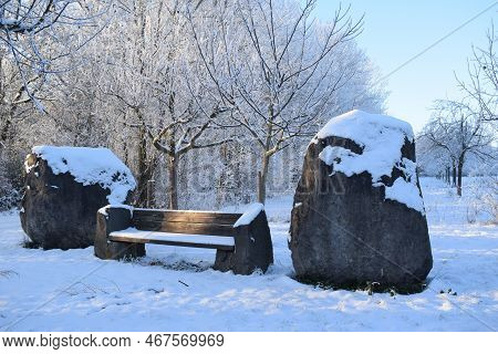 Park Bench Between Big Volcano Rocks With Snow