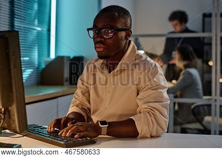 African American Programmer Concentrating On His Online Work On Computer Working In Office Till Late