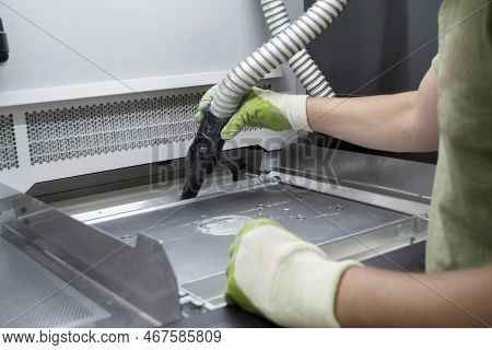 A Male Worker Cleans The Surface Of An Industrial 3d Printer From White Powder With A Vacuum Cleaner