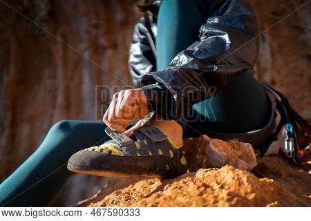 A Young Girl Puts On Special Climbing Shoes On Her Legs Before Climbing Outdoor Training, Hands And 