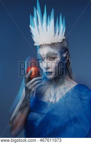 Ice Queen With Red Apple Against Blue Background