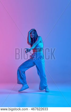 Young Expressive Girl Dancing Hip-hop Isolated Over Gradient Pink Blue Background In Neon Light