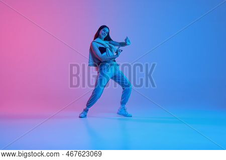 Young Stylish Girl, Hip-hop Dancer Performing Over Gradient Pink Blue Background In Neon Light