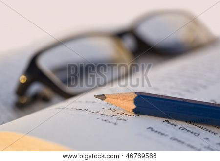 Crayon et verres sur un livre