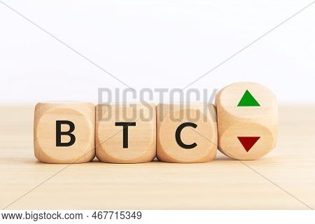 Btc Or Bitcoin Price Up Or Down Concept. Text On Wooden Blocks And Turning Dice With Up And Down Arr