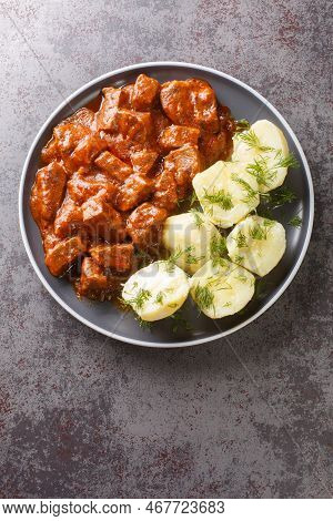 Vienna Goulash Or Wiener Saftgulasch Served With Boiled Potatoes Closeup On The Plate On The Table. 