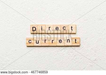 Direct Current Word Written On Wood Block. Direct Current Text On Cement Table For Your Desing, Conc