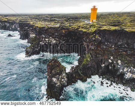 Orange Svortuloft Lighthouse And Stormy Sea Down Bellow