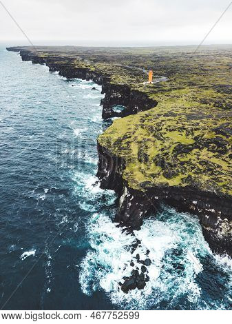 Vertical Photo Of Black Volcanic Rocky Coast And Svortuloft Lighthouse