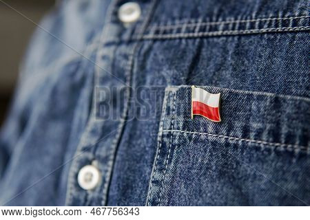 Metal Badge With The Flag Of Poland Is Pinned On Blue Jeans Jacket. Poland Patriotism Concept. Indep