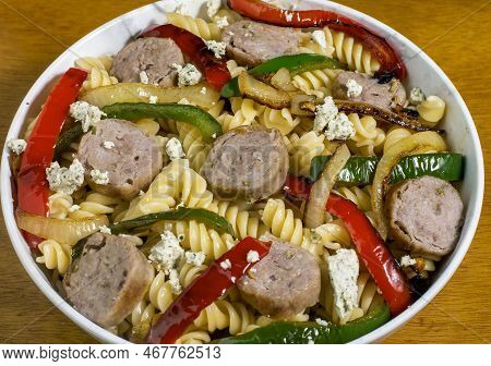 Rotini Top With Sauteed Peppers And Onion Served With Italian Sausages And Goat Cheese