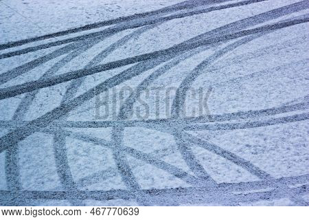 Car Tire Tracks In Fresh Snow On Road. Car Trail Pattern On Slippery, Icy Winter Road