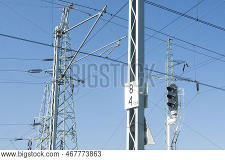 Rail Signal, Catenary Overhead Line, Power Transmission Line Tower Sunlit Against Blue Sky