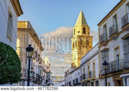 Street Of An Andalusian Village At Sunset, Decorated With Christmas Lights Between The White Houses,