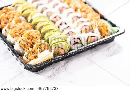 Pre-packaged Variety Of Sushi And Sushi Rolls In A Plastic Tray.