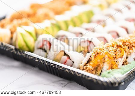 Pre-packaged Variety Of Sushi And Sushi Rolls In A Plastic Tray.