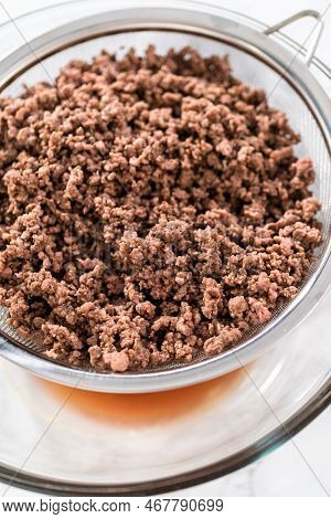 Draining Brown Ground Beef Meshed Strainer To Make Homemade Hamburger Helper.