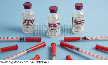 Insulin Injection Syringe Arranged Around Humalog Insulin Injection Solution  On Blue Background.sid