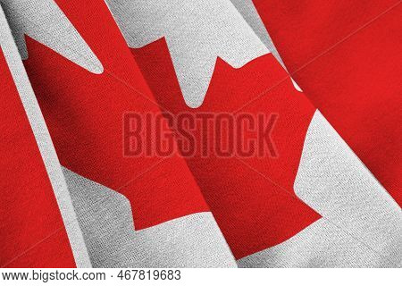 Canada Flag With Big Folds Waving Close Up Under The Studio Light Indoors. The Official Symbols And 
