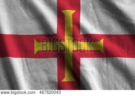 Guernsey Flag With Big Folds Waving Close Up Under The Studio Light Indoors. The Official Symbols An