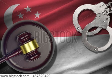 Singapore Flag With Judge Mallet And Handcuffs In Dark Room. Concept Of Criminal And Punishment, Bac