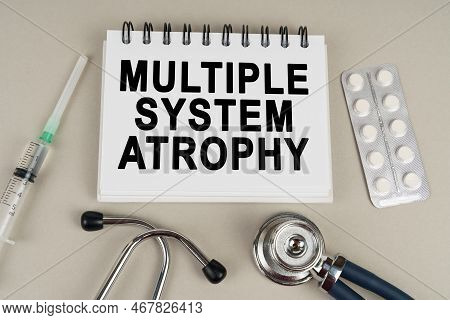Medical Concept. On A Gray Surface, A Syringe, A Thermometer, A Stethoscope, A Blister And A Notepad