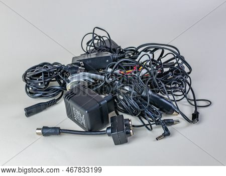 Bunch Of Old Wires, Connections And Chargers For Modern Devices Close-up On A Light Background. Pile