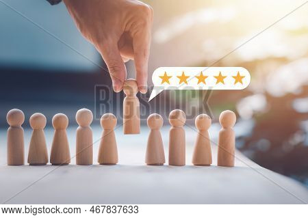 Hr Manager (human Resources) Or Employer Hand Choose Takes Person Wooden Doll. Leader Stands Out Fro