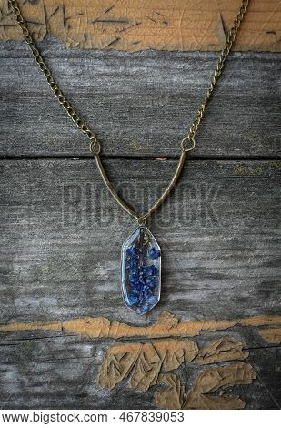 Close Up Pendant With Small Blue Flowers Concept Photo. Craft Jewelry. Top View Photography With Old