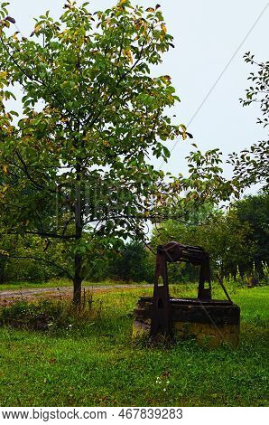 Close-up View Of Abandoned Old Well In Ukrainian Village. Ancient Draw-well Surrounded By Autumn Col